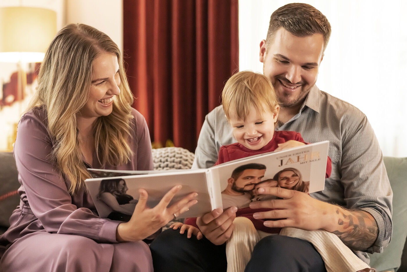 Eine Familie betrachtet gemeinsam ein Fotobuch.